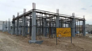 اسکلت بتنی در حال ساخت ایستگاه آتشنشانی با ستونها و داربستهای فلزی در محیط شهری